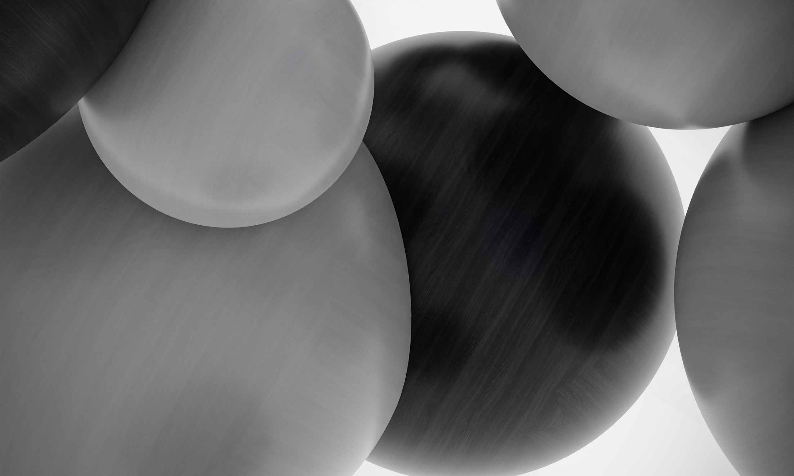 Abstract grayscale close-up of overlapping smooth, rounded shapes with brushed-metal texture.