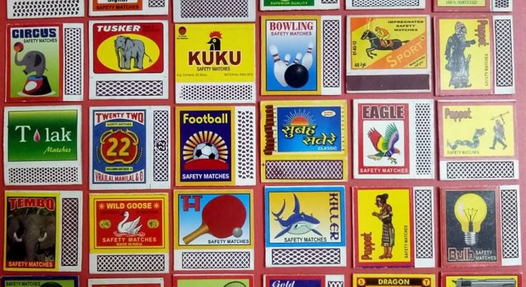 Grid of colorful vintage matchbox labels arranged in rows and columns, showcasing diverse logos and artwork.