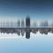 City skyline reflected in a calm river against a clear blue sky, with tall buildings along the waterfront.