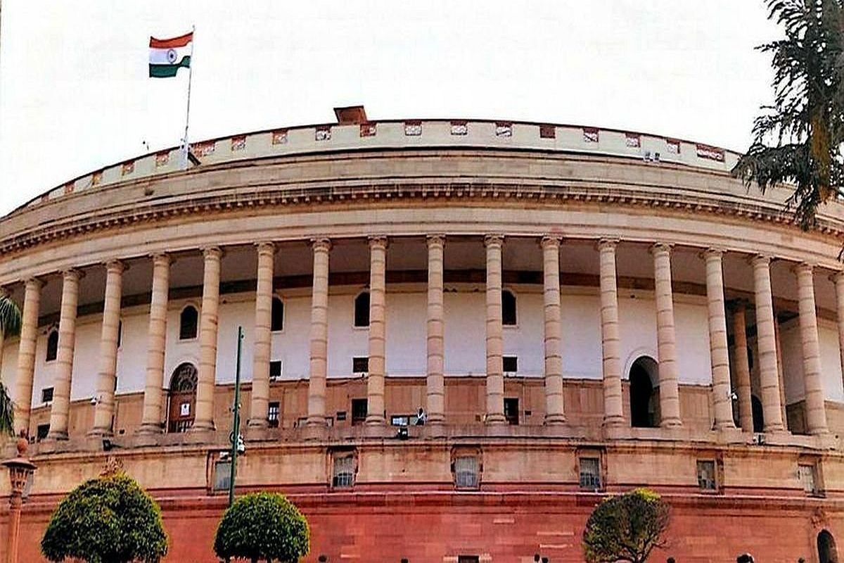 Indian Parliament building with a row of tall columns and the Indian flag on top]