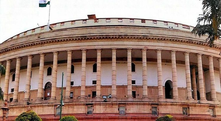 India Parliament building with tall columns and Indian flag atop the dome-like façade